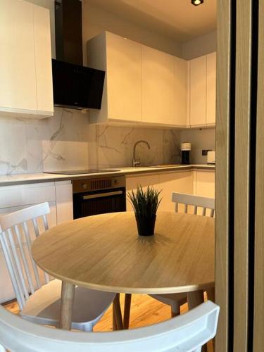 uma cozinha com uma mesa de madeira e armários brancos em Luxury 2 bedroom apartment and garden 