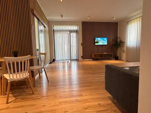 a living room with a table and chairs and a television at Luxury 2 bedroom apartment and garden 
