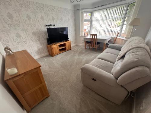 ein Wohnzimmer mit einem Sofa und einem TV in der Unterkunft Golf Open Property to Rent Dates available 15th - 23th July in Wallasey