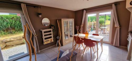 a dining room with a table and chairs and a mirror at Le Chant du Coq in Chassepierre