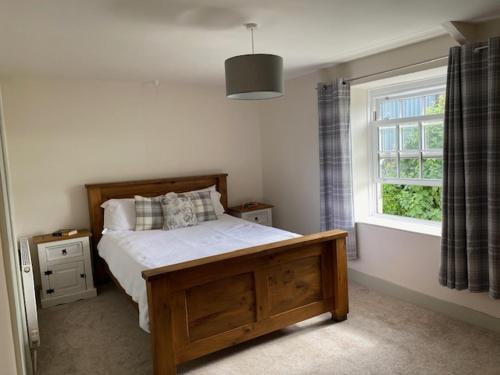 een slaapkamer met een bed en een raam bij The Cottage in Exeter