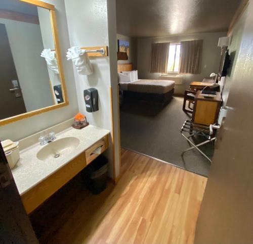 a bathroom with a sink and a mirror and a bed at Rocker Inn in Butte