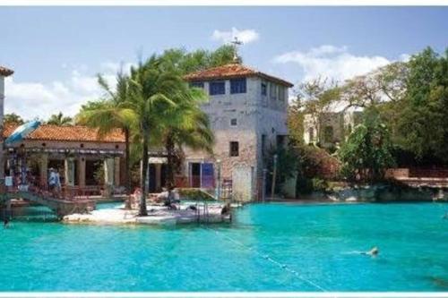 a large pool of blue water in front of a building at Sol Miami #1 with free parking on premises in Miami