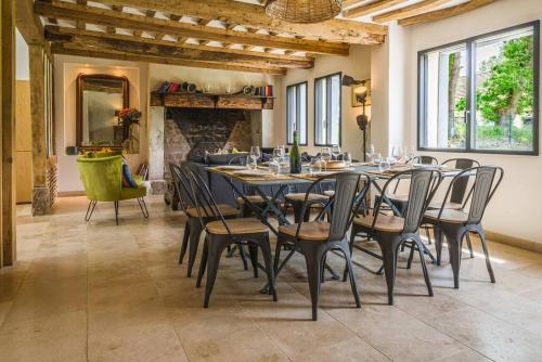 une salle à manger avec une table et des chaises et une cheminée dans l'établissement Superbe propriété bord de mer - Le Clos Ricarda, à Sainte-Marguerite