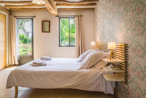 une chambre avec un grand lit avec une tête de lit en bois dans l'établissement Superbe propriété bord de mer - Le Clos Ricarda, à Sainte-Marguerite
