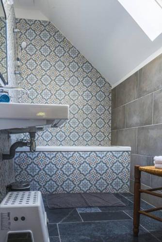 La salle de bains est pourvue d'un lavabo et d'un mur carrelé. dans l'établissement Superbe propriété bord de mer - Le Clos Ricarda, à Sainte-Marguerite