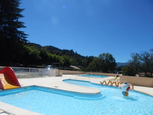 een zwembad met twee glijbanen en een waterpark bij camping bonneval in Jaujac