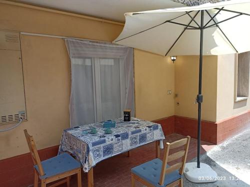 een tafel met twee stoelen en een parasol bij b&b Poseidone in Alassio