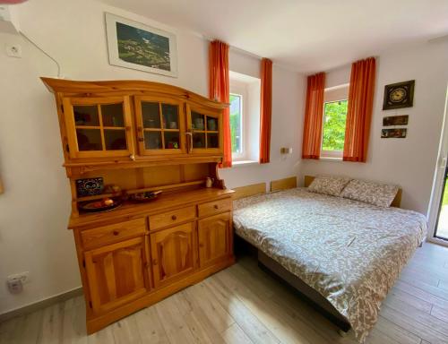 Schlafzimmer mit einem Bett und einem Holzschrank in der Unterkunft Apartma EMI in Bovec