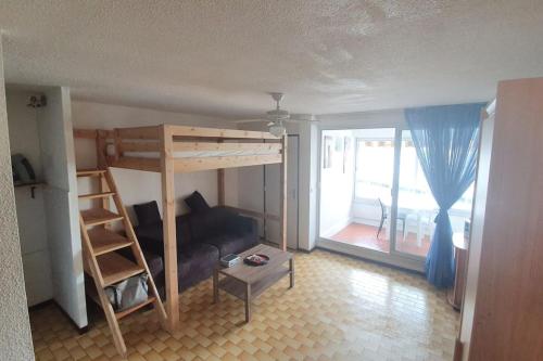 Cette chambre dispose de lits superposés et d'un canapé. dans l'établissement Appart. calme 5 Pers vue sur le port de gruissan, à Gruissan