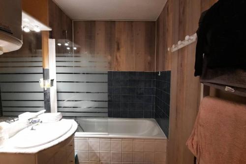 une salle de bain avec un lavabo et une baignoire dans l'établissement Appart. calme 5 Pers vue sur le port de gruissan, à Gruissan