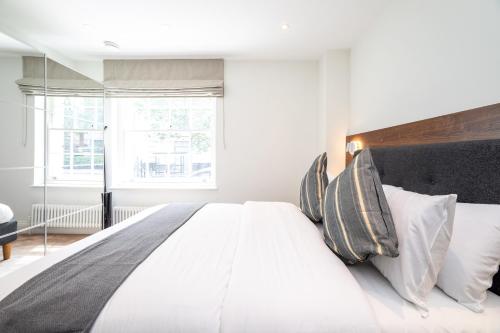 a bedroom with a large white bed with white pillows at The Heart of Westminster in London
