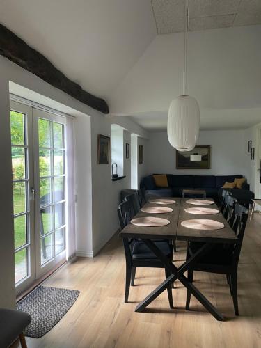 uma sala de jantar com uma mesa e um sofá em Bækgaardens bed and breakfast em Odense