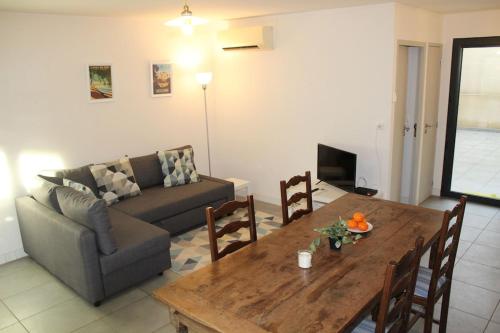 a living room with a wooden table and a couch at 2 bedroom home with shared pool in lovely market town of Olonzac in wine region in Olonzac