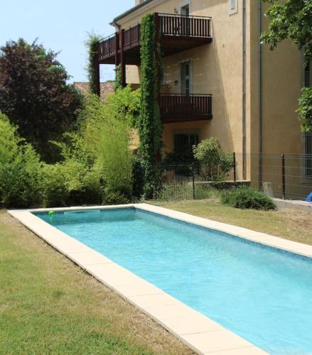 une piscine bleue en face d'un bâtiment dans l'établissement 2 bedroom home with shared pool in lovely market town of Olonzac in wine region, à Olonzac