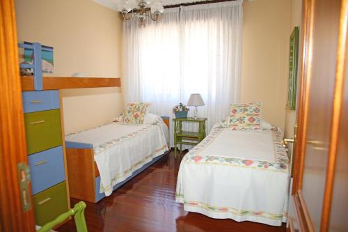 a small bedroom with two beds and a window at Os de Rey in Pontevedra