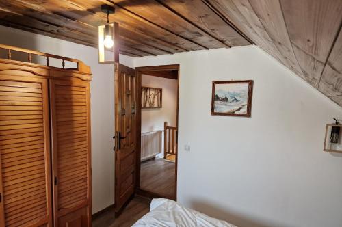 1 dormitorio con cama y techo de madera en Cabana din Rusca, en Sebeşu de Jos