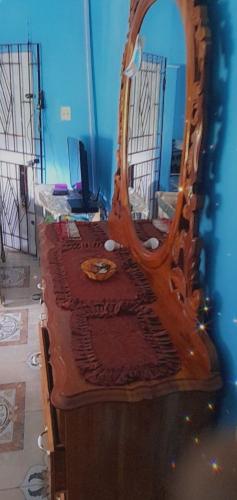 a wooden bed with a mirror on a blue wall at fee easy studio, in 15 minutes away you can locate YS FALLS, 5 mins way safari tour, HALF HOUR there come LOVERS LEAP, pelican bar, treasure beach, Appleton easte..and the list goes on in Black River