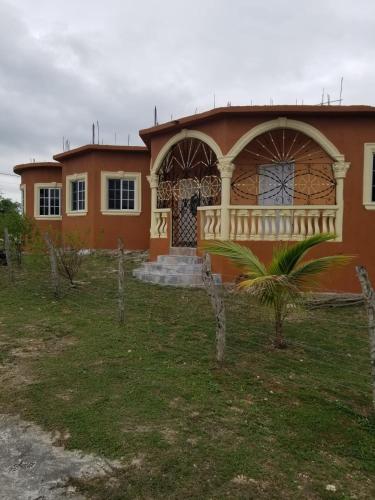 a house with a balcony on the front of it at fee easy studio, in 15 minutes away you can locate YS FALLS, 5 mins way safari tour, HALF HOUR there come LOVERS LEAP, pelican bar, treasure beach, Appleton easte..and the list goes on in Black River