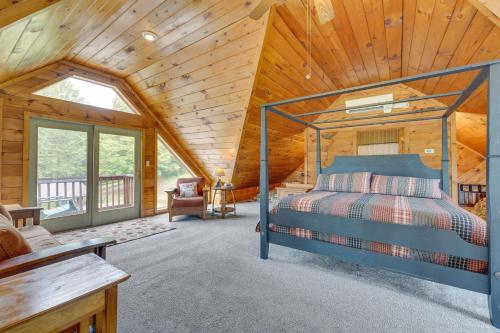 una camera con un letto in una cabina di legno di 3-Acre Benezette Cabin with Hot Tub, Grill and Mtn View a Benezette
