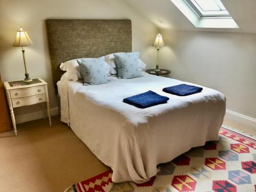 1 dormitorio con 1 cama con 2 toallas azules en Mulberry Barn Annx - Self Contained Near Winchester, en Micheldever