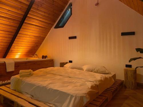 una camera con un grande letto in una stanza con soffitti in legno di OYARC SAPANCA VILLA / BUNGALOW a Sakarya