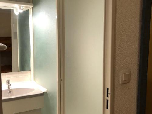 uma casa de banho com um lavatório e um espelho em Appartement Enchastrayes, 2 pièces, 5 personnes - FR-1-165A-144 em Enchastrayes