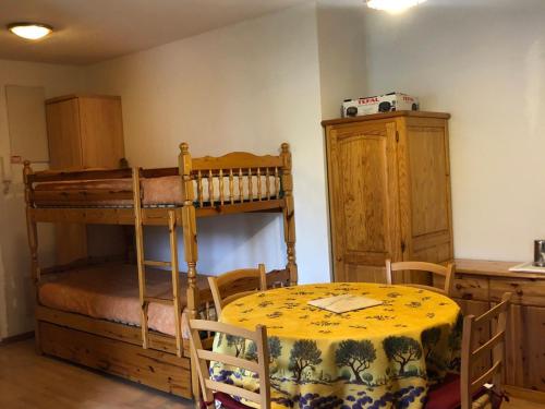 a room with a bunk bed and a table and a table and chairs at Charmant T2 Cabine au pied des pistes avec parking privé à Enchastrayes - FR-1-165A-144 in Enchastrayes