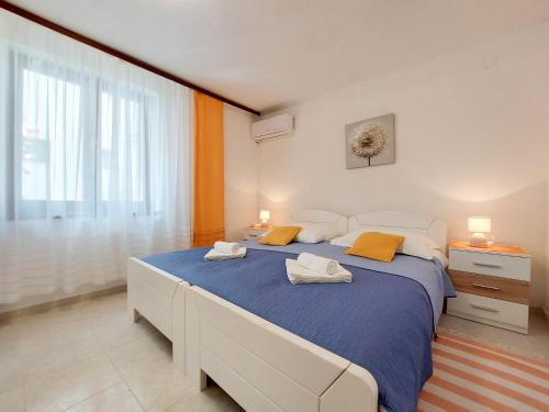 een slaapkamer met een groot bed en een groot raam bij Apartments Ivanka in Krk