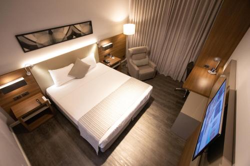 una camera d'albergo con letto e TV di JL Hotel by Bourbon a Foz do Iguaçu