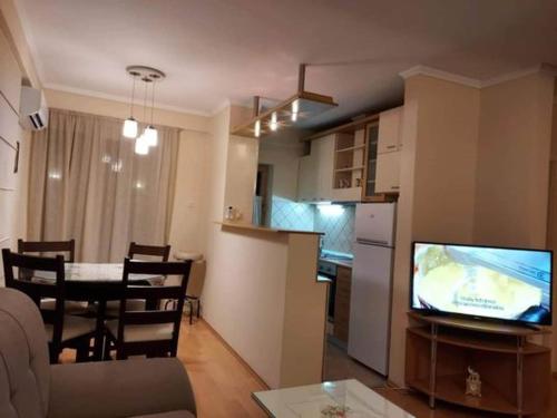 Ellie's place في بيتولا: مطبخ وغرفة معيشة مع طاولة وتلفزيون