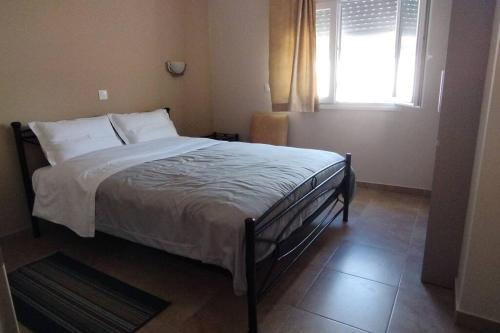 a bed in a bedroom with a window at Smailis apartment 1 in Koróni