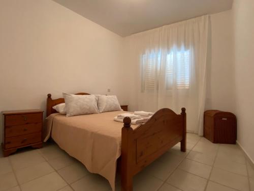 ein Schlafzimmer mit einem großen Bett und einem Fenster in der Unterkunft Corner townhouse in Regina Gardens, Pafos in Paphos City