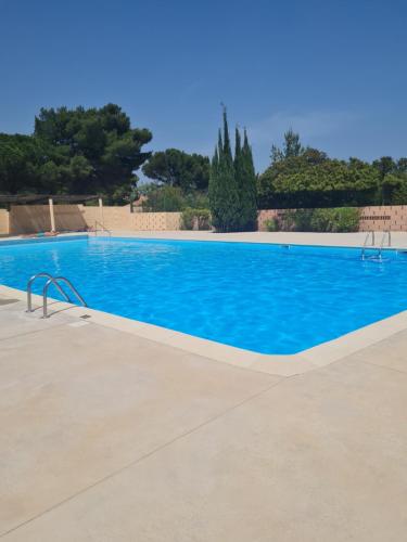 a large swimming pool with blue water at L'oasis de port Fitou in Fitou