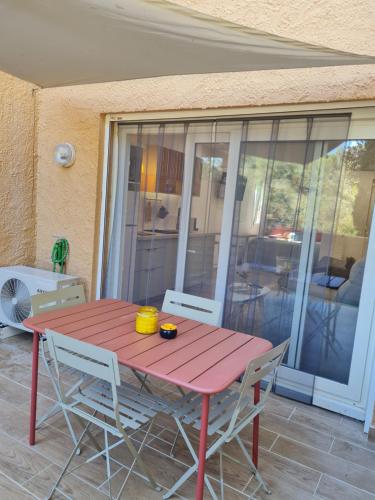 czerwony stół i krzesła na patio w obiekcie L'oasis de port Fitou w mieście Fitou