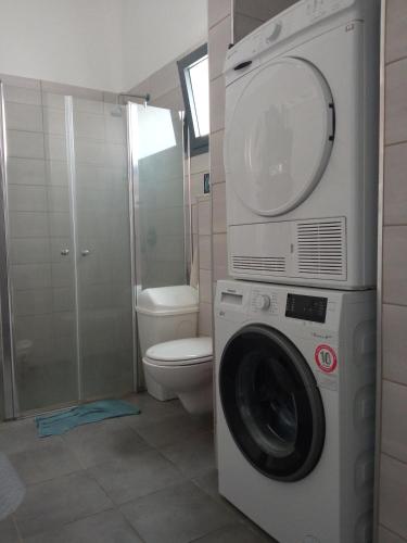 a bathroom with a washing machine and a toilet at Квартира с высокими потолками. in Migdal