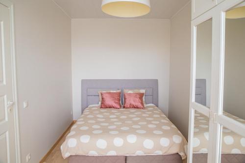 a small bedroom with a bed with two pink pillows at Oja residents in Pärnu