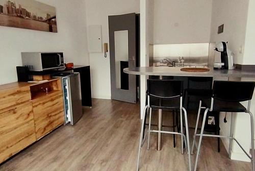 una cocina con barra y un bar con taburetes en Chazi, en Toulouse