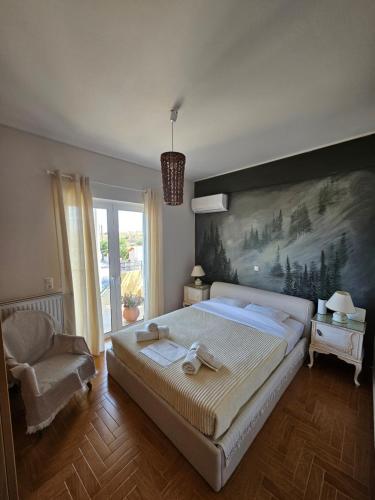 - une chambre avec un grand lit orné d'une peinture murale dans l'établissement KD Country Home, à Thorikón