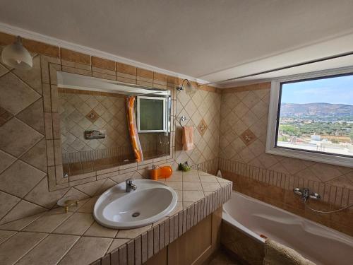 La salle de bains est pourvue d'un lavabo et d'une fenêtre. dans l'établissement KD Country Home, à Thorikón
