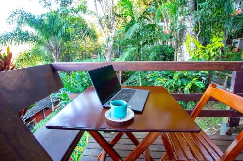 a laptop computer sitting on a table on a balcony at Casas Temporada Aldeia Niura Opy in Florianópolis
