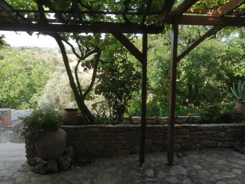 eine Terrasse mit einer Steinmauer mit Topfpflanzen in der Unterkunft ΑΝΑΒΑΤΟΣ ΕΞΟΧΙΚΗ ΚΑΤΟΙΚΙΑ ΙΙ in Chios