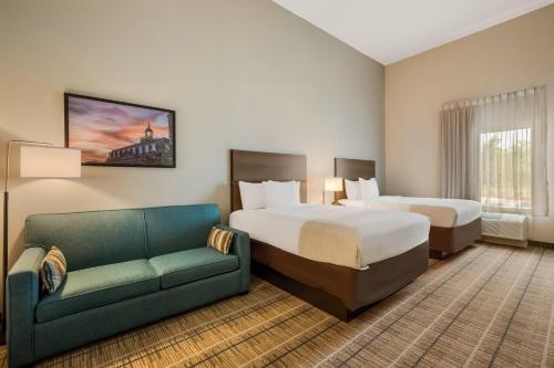 une chambre d'hôtel avec deux lits et un canapé dans l'établissement Hawthorn Extended Stay by Wyndham Sulphur Lake Charles, à Sulphur
