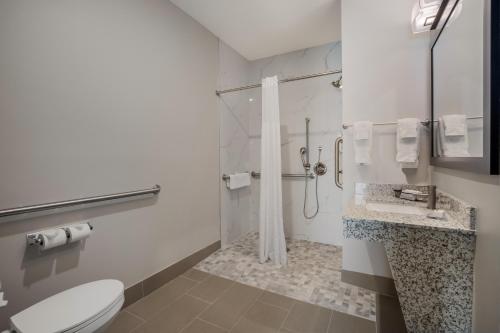 a bathroom with a shower and a toilet and a sink at Hawthorn Extended Stay by Wyndham Sulphur Lake Charles in Sulphur