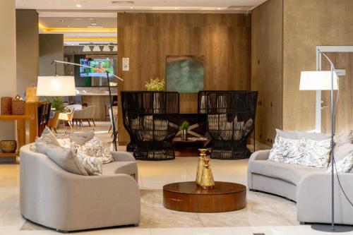 a living room with two couches and a table at JL Hotel by Bourbon in Foz do Iguaçu