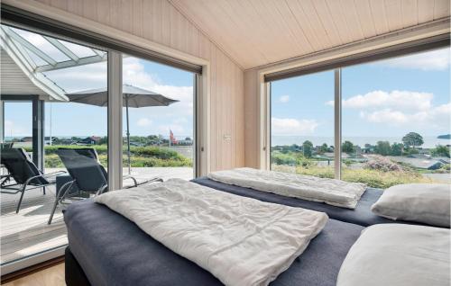 twee bedden in een kamer met grote ramen bij Nice Home In Hejls With Wifi in Hejlsminde