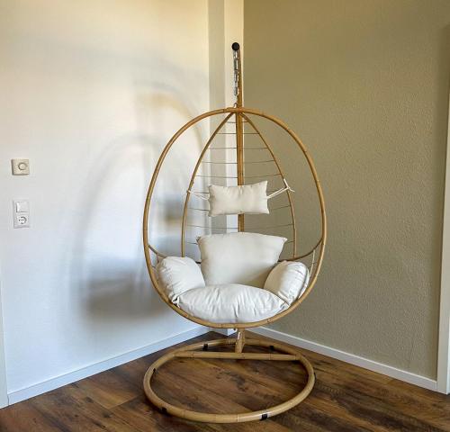 einen runden Stuhl mit weißen Kissen in einem Zimmer in der Unterkunft Bamboo City in Magdeburg