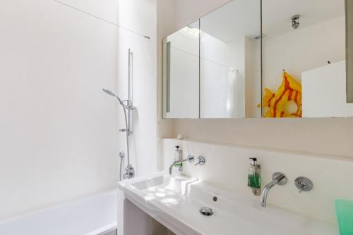 Un baño blanco con lavabo y espejo. en Villa Almond, en Skopelos Town