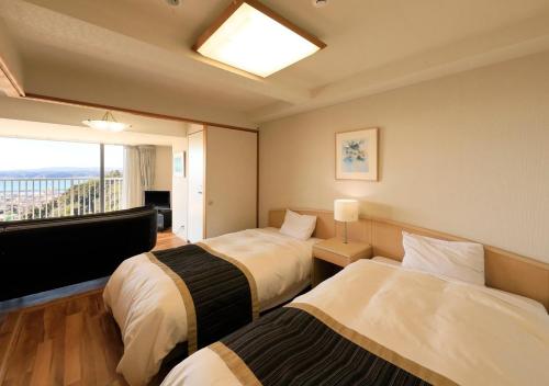 ein Hotelzimmer mit 2 Betten und einem Fenster in der Unterkunft Katsuura Hilltop Hotel & Residence - Vacation STAY 73528v in Katsuura
