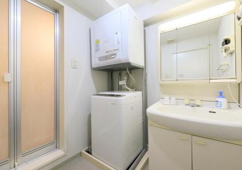 ein Badezimmer mit einem Waschbecken, einer Waschmaschine und einem Trockner in der Unterkunft Katsuura Hilltop Hotel & Residence - Vacation STAY 73528v in Katsuura